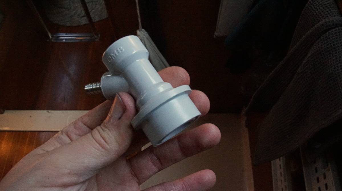 a hand holding a ball-lock keg coupler