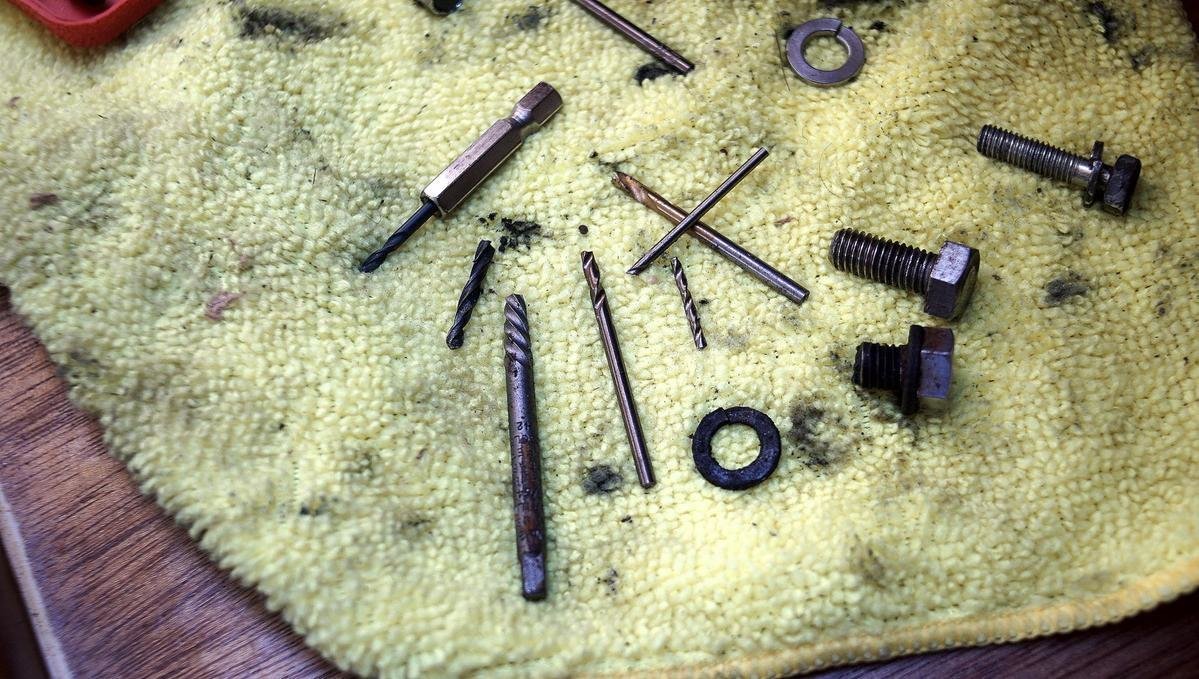A photo of broken drill bits, a broken extractor and damaged bolts
