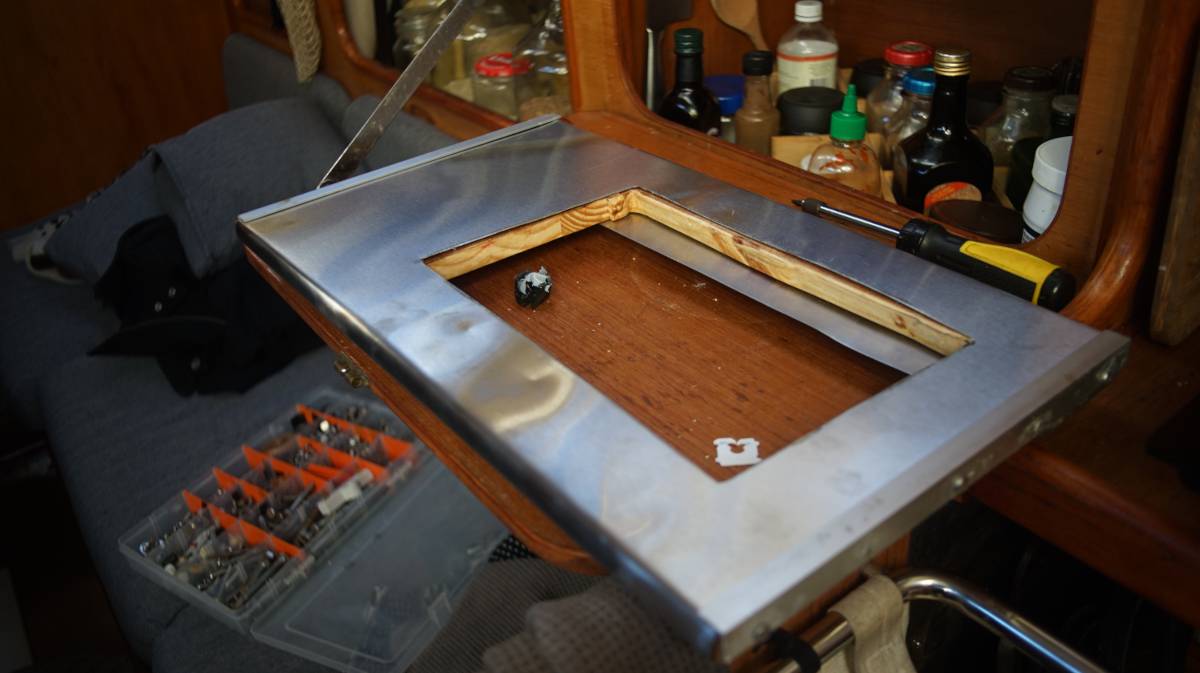 a thin piece of stainless steel wrapped around a wooden board with a rectangular hole in the center