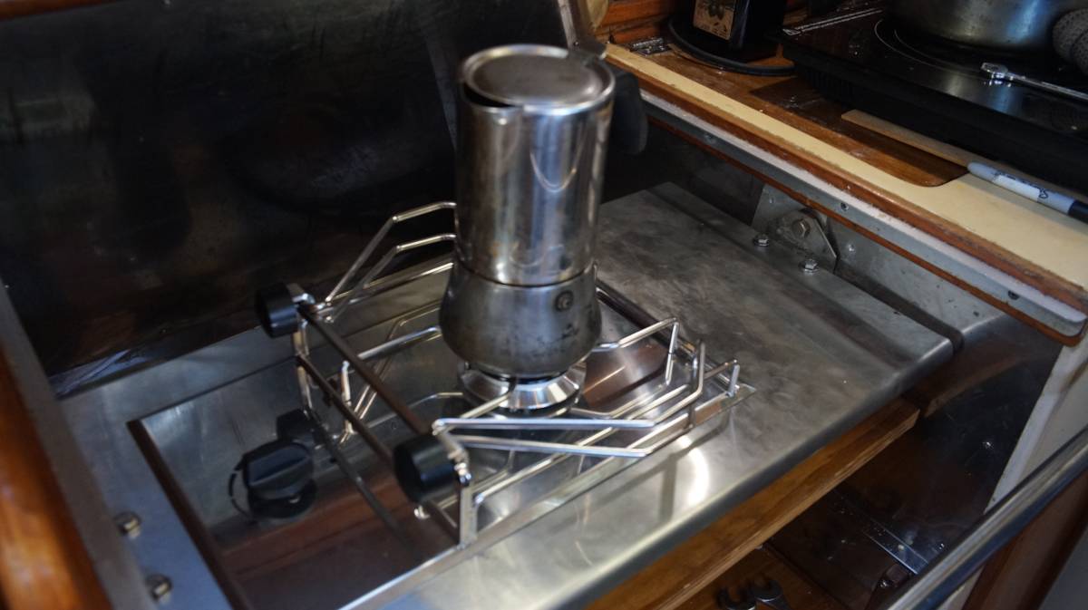 a moka pot held by pot holders on a sailboat gimballed stove