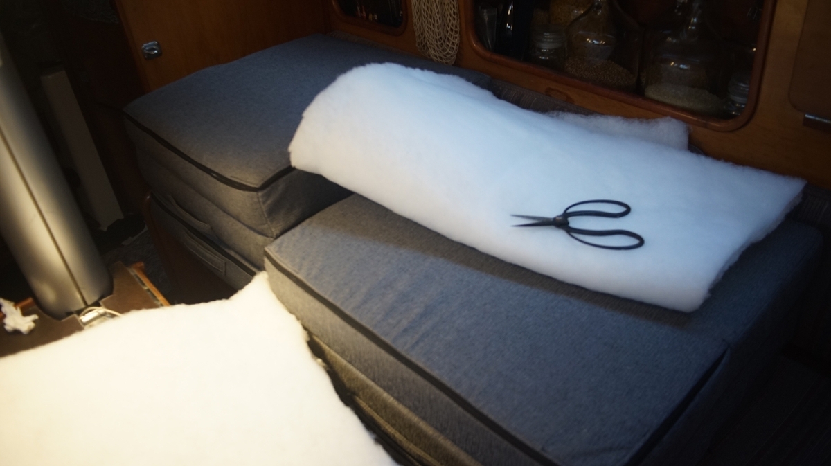 travel bed with a sheet of poly batting and scissors overtop