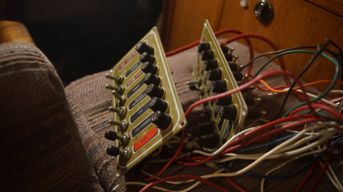 a photo of old breaker panels stripped from the wall with their wires hanging