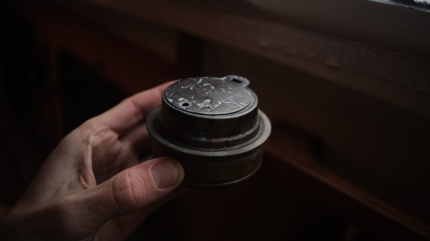 A photo of a hand holding a trangia alcohol burner