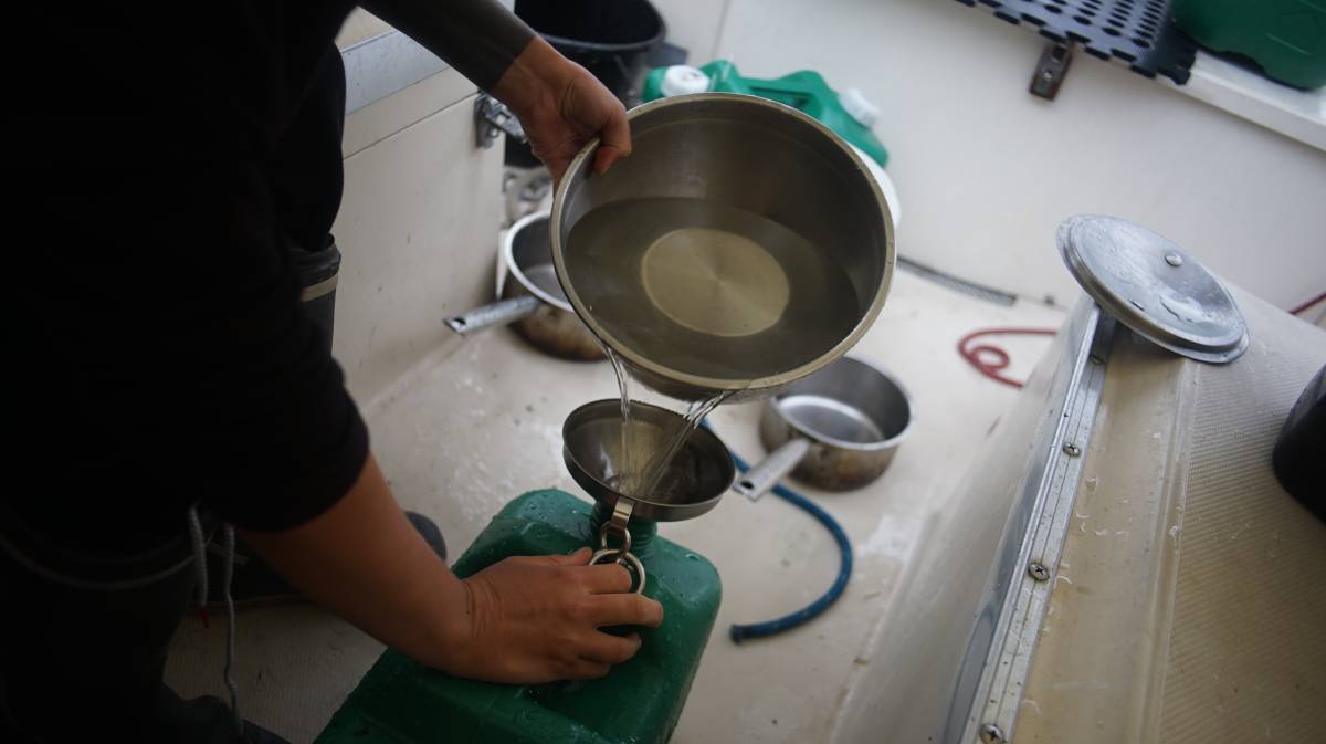 rek emptying bowls full of water into bins using a funnel