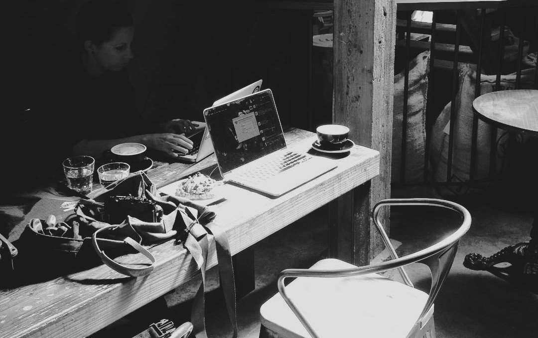 rek in a cafe with a laptop