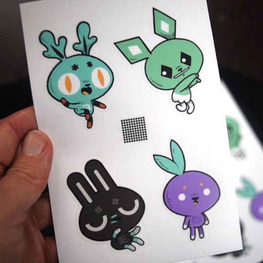 a hand holding a sticker sheet with cartoon rabbits