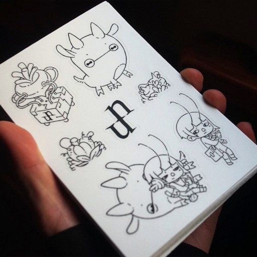 a hand holding an uxn sticker sheet