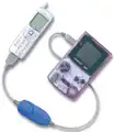 The blue-cable adapter connecting a mobile phone to a Game Boy Color