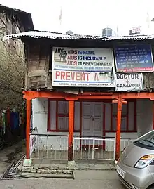 A run down a two-story building with a number of signs related to AIDS prevention