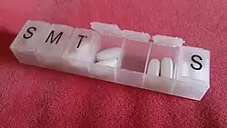 Plastic box with separate, labeled compartments for each day of the week