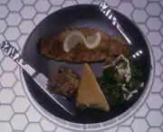 A dish of cooked catfish, with lemon