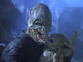 A Reptohumanoid adult holding an infant