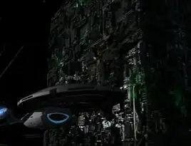 The Borg cube containing Seven of Nine alongside the USS <i>Voyager</i>