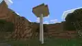 A brown 13 block-tall huge mushroom generated in a swamp in Bedrock Edition.