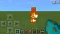 A burning zombie in Bedrock Edition emitting unique fire particles.