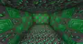 A room with placed emerald ores, including blocks of emerald and thrown emerald items.
