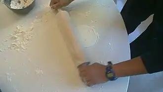 Rolling out the batter with a rolling pin.