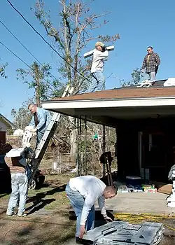 Gulfport, Miss. (Jan. 7, 2006) - Seabees from the Naval Mobile Construction Battalion One (NMCB-1) First Class Association move shingles from the ground to the roof of a house damaged by Hurricane Katrina. NMCB-1 First Class Association makes community service projects its main focus while in homeport. U.S. Navy photo by Photographer's Mate 3rd Class Ja'lon A. Rhinehart.