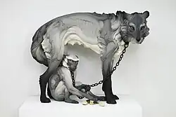 Title: "Tribute" from the exhibition "The Other" Year: 2017 Dimensions: Wolf: 58 in. length, 46 in. height, 31 in. width Materials: Stoneware, paint, hand-forged steel collars and chain