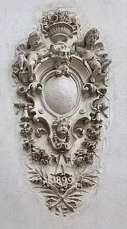 Arabesque with a big and blank cartouche and cherubs, on a wall of Intrarea Costache Negri no. 1, Bucharest, unknown architect, 1899