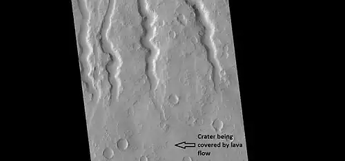 Lava channels on flank of Hecates Tholus, as seen by HiRISE under HiWish program. A crater has been partially covered over by lava flows. This crater will be enlarged in the next image.