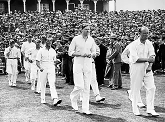 Cricketers walking on to a ground