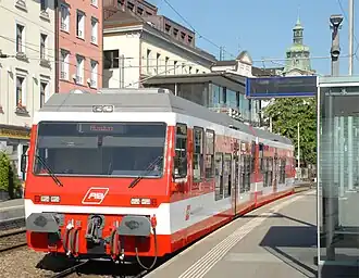 Electric railcar with red and white horizontal stripes