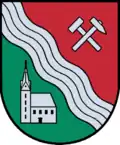 The new municipal coat of arms, awarded in 2016, shows a silver church, this being the parish church.