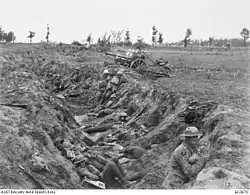 a black and white photograph of a trench with troops in it