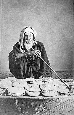 An elderly Egyptian vendor selling bread, 1870s