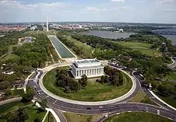 An aerial photo a large white building with big pillars.