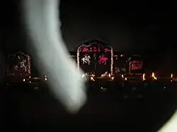 Akhand Jyoti at night with images of mounted soldiers which reflect in red and white.