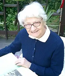 Portrait photo of Dr. Asuman Baytop reading in a chair outside