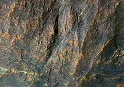 Banded bedrock in Terra Sabaea, in the ancient highlands north of the Hellas basin. The image is about a kilometer wide. Colors are enhanced.