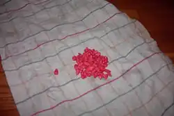 Corn kernels treated with taint, a fungicide. Sifering agents are provided with a dye for identification, since tainted goods are excluded from feeding.