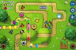 Screenshot of a game of Bloons TD 5 Mobile. The game is currently played on Round 34 with a number of monkey and machine towers, many of which have low-level upgrades.
