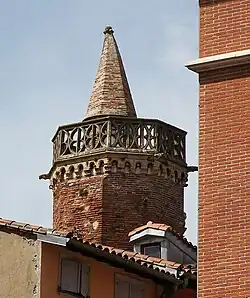 Top of the tower with balustrade and faux machicolations.