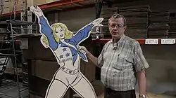 Buddy Saunders (right) in his warehouse with Dallas Cowboy Cheerleader cutout during production of the short documentary "Dallas Marvels" in 2015