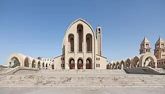 Modern cathedral building with distinctive twin bell towers and arched entrance in contemporary Coptic architectural style