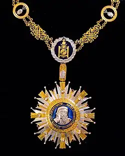 A gold and silver-coloured medal depicting the silhouette of a man.