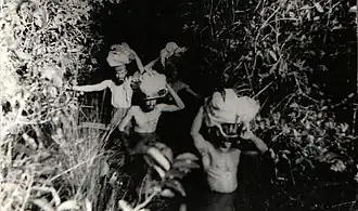 Three people are seen on the woods