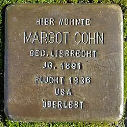 Gravestone reading “HIER WOHNTE MARGOT COHN 8EB LIEBRECHT J8 1891 FLUCHT 1938 USA ÜBERLEBT”