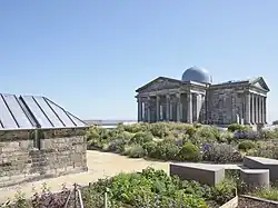 Restored City Observatory, which opened as Collective, centre for contemporary art, in 2018. Observatory building and Transit House shown with colourful flowerbeds in foreground.