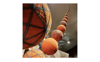 A convergent series of mari (unembroidered) and temari (embroidered) balls rises above the installation