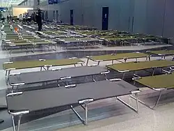 For passengers stranded overnight, secure area at O'Hare International Airport with dimmed lights, cots, pillows, blankets, and toiletries (2008)[29]