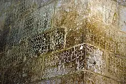 A stone wall bearing engraved crosses