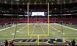 Photograph of a football field taken from the end zone showing goal posts in the foreground