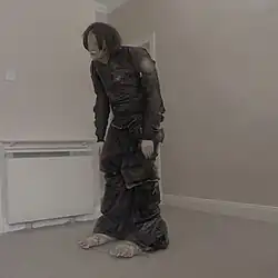 A person wrapped in plastic, hunched over