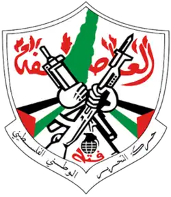 Crest of Fatah, featuring two hands adorned with Palestinian flags wielding rifles, map of Palestine and a grenade