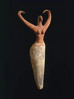 Image 6Naqada figure of a woman interpreted to represent the goddess Bat with her inward curving horns. Another hypothesis is that the raised arms symbolize wings and that the figure is an early version of the white vulture goddess Nekhbet, c. 3500–3400 B.C.E. terracotta, painted, 11+1⁄2 in × 5+1⁄2 in × 2+1⁄4 in (29.2 cm × 14.0 cm × 5.7 cm), Brooklyn Museum (from Prehistoric Egypt)
